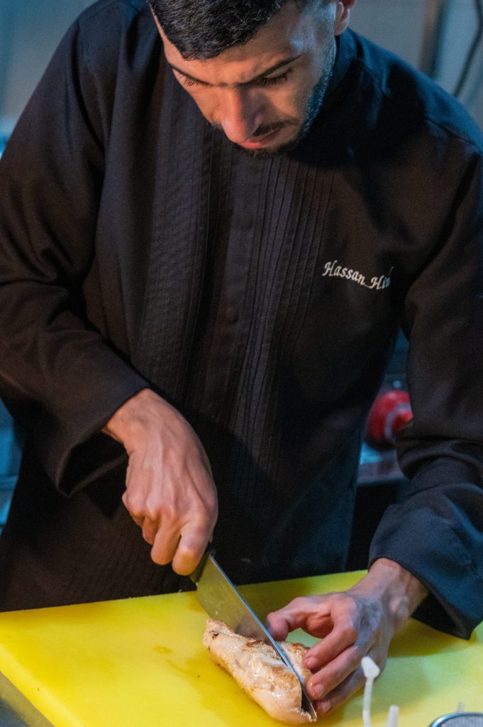 Chef preparing a dish in the kitchen of the Kach Kech restaurant at Riad Al Rimal